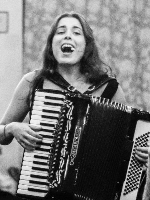 Anavi tocando el acordeón en directo, riendo