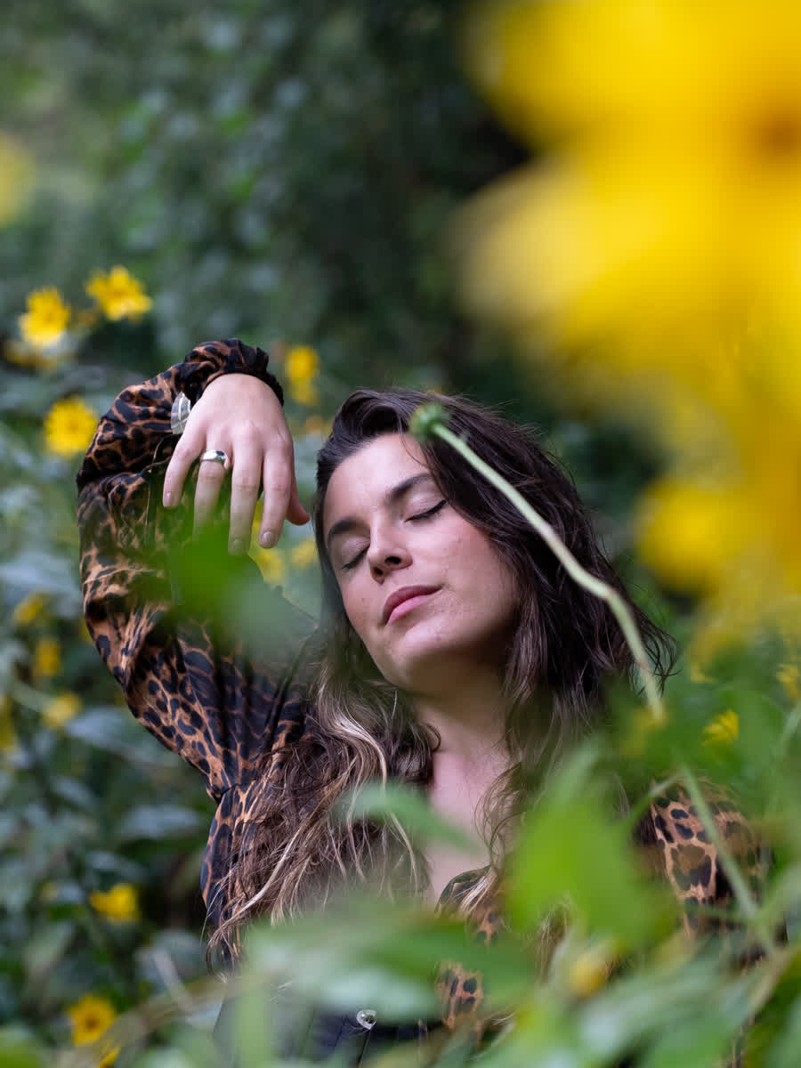 Anavi con los ojos cerrados, entre flores amarillas